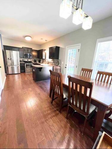 a kitchen with a wooden table and chairs and a kitchen with a counter at Beautiful home near Carowinds, Ballantyne in Fort Mill
