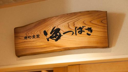 a wooden sign with chinese writing on a wall at Onyado Nono Sakaiminato Natural Hot Spring in Sakaiminato