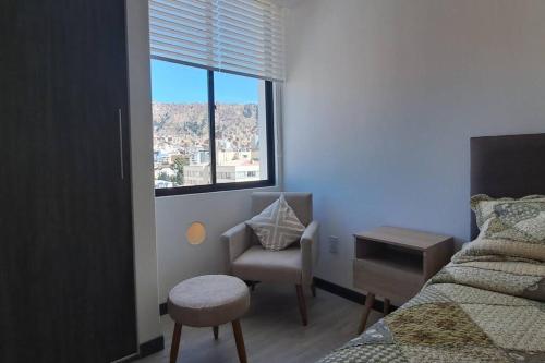 una camera da letto con un letto, una sedia e una finestra di Penthouse Titanium Mac a La Paz