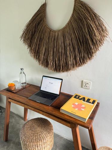 a desk with a laptop and a book on it at Amar Boutique Hotel in Canggu