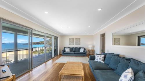 a living room with a couch and a table at Coral Sea in Pearl Beach