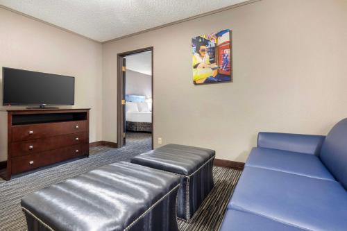 a living room with a couch and a tv at Best Western McCarran Inn in Las Vegas