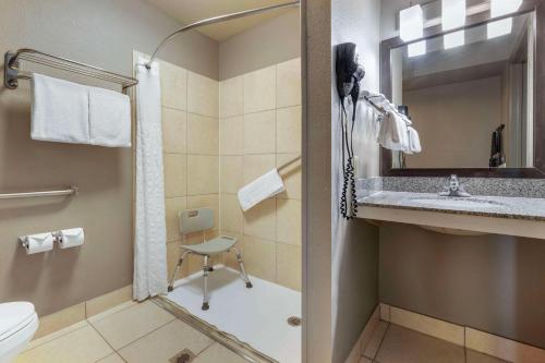 a bathroom with a shower and a toilet and a sink at Best Western McCarran Inn in Las Vegas