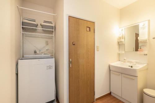a small bathroom with a refrigerator and a sink at Osaka Kanzakigawa Royal駅徒步1分 "private house 3 bed rooms "一棟貸し宿 in Osaka