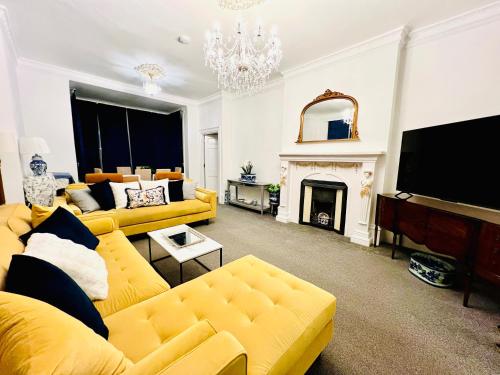 a living room with a yellow couch and a fireplace at Flat 3 Marine Parade House, 1 East Cliff - Next to Dover Port, White Cliffs, Beach, Castle in Dover