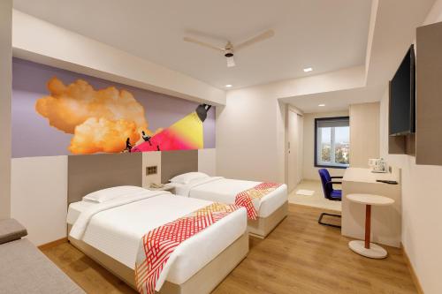 a bedroom with two beds and a painting on the wall at Ginger Vishakhapatnam Gajuwaka in Visakhapatnam