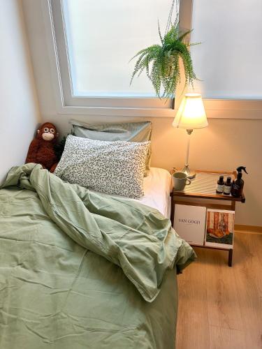 a bedroom with a bed with a teddy bear sitting on it at Pocket Seoul Hostel Hongdae in Seoul