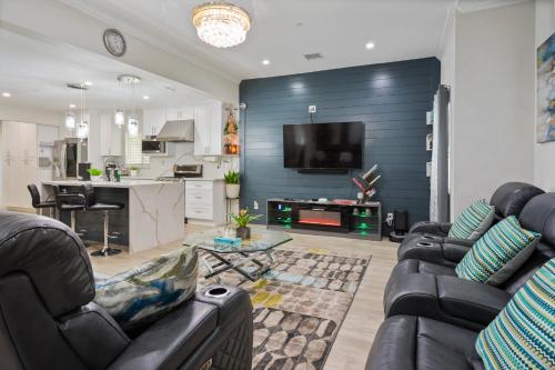 a living room with two leather couches and a kitchen at LA Home - FIFA Soccer, NBA Games, Universal Studios in Los Angeles