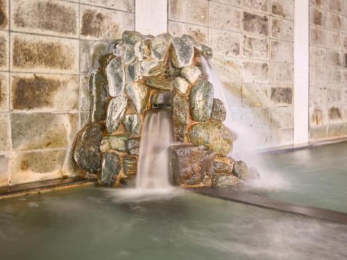 a water fountain in a stone wall at Shuzenji Onsen Hotel Takitei in Izu