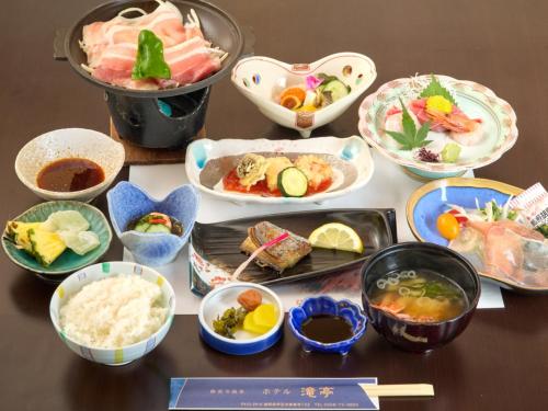 a table with various dishes of food on it at Shuzenji Onsen Hotel Takitei in Izu