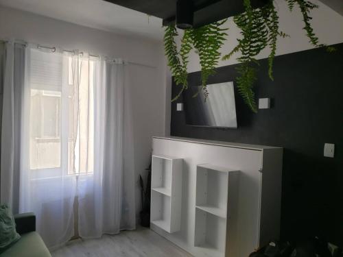 uma sala de estar com uma prateleira branca e uma janela em Studio Praia de Botafogo no Rio de Janeiro
