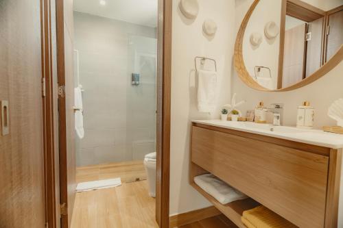 a bathroom with a sink and a toilet and a mirror at Downtown Punta Cana Central Park 1 Bedroom B-300 in Punta Cana