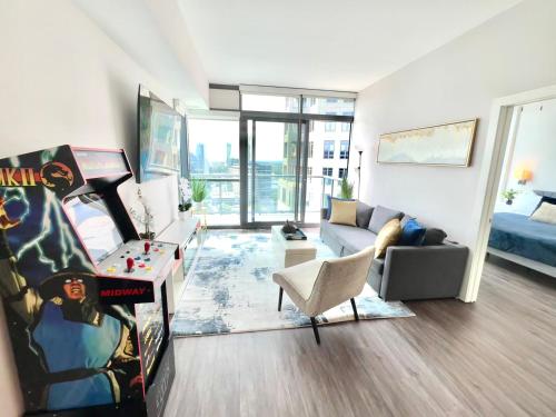 a living room with a couch a chair and a room with a bed at Skyline Retreat Penthouse, Top Floor, Year round Pool, City View! in Atlanta