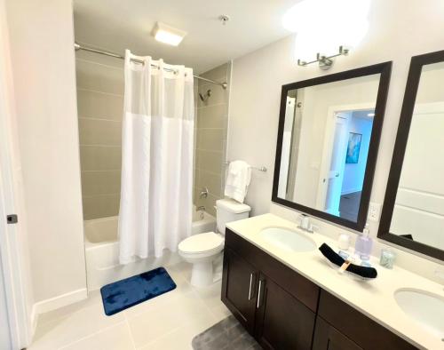 a bathroom with a sink and a toilet and a mirror at Skyline Retreat Penthouse, Top Floor, Year round Pool, City View! in Atlanta