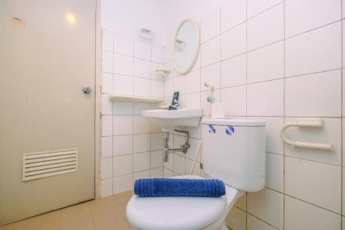 a bathroom with a toilet and a sink at Comfy and New Furnished at 2BR Kebagusan City Apartment By Travelio in Jakarta