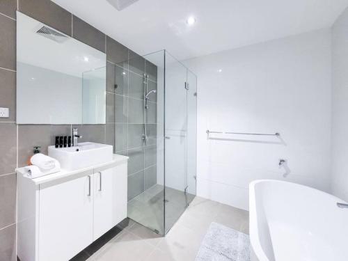 a white bathroom with a sink and a shower at One bedroom Apartment walk to Gordon Train Station in Gordon