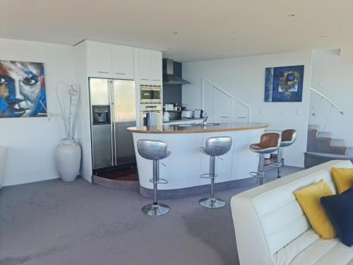 a kitchen with a bar with stools and a couch at Starship Enterprise in Wellington