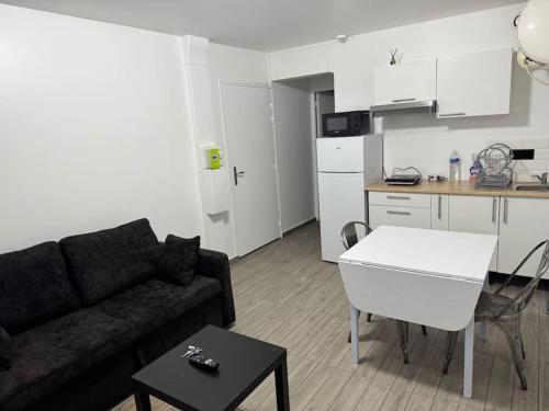 un salon avec un canapé et une cuisine dans l'établissement Appartement G, RESIDENCE DU RENOUVEAU, Stade de France, idéal pour 4 pers, à Saint-Denis