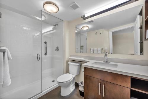a bathroom with a toilet and a shower and a sink at Candlewood Suites - Dumfries - Quantico by IHG in Dumfries