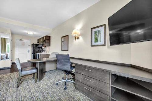 an office with a desk with a television and chairs at Candlewood Suites - Dumfries - Quantico by IHG in Dumfries