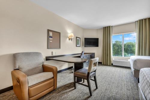a hotel room with a desk and a chair at Candlewood Suites - Dumfries - Quantico by IHG in Dumfries