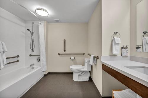 a bathroom with a toilet and a tub and a sink at Candlewood Suites - Dumfries - Quantico by IHG in Dumfries