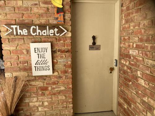 a brick wall with a sign next to a door at The Chalet Bed and Breakfast-peace and quiet in the country 12 minutes from City in Dunedin