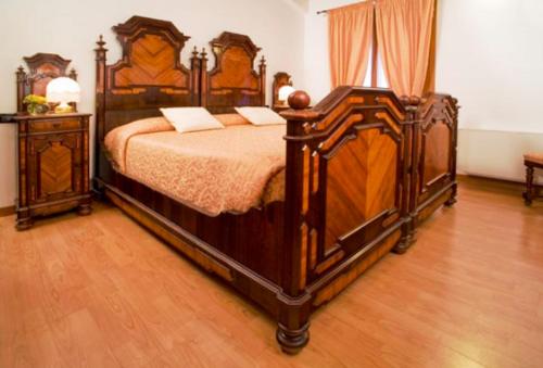 a bedroom with a large wooden bed and two night stands at Agriturismo Villa Mocenigo in Mirano