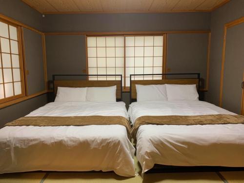 Dos camas una al lado de la otra en una habitación. en ネイチャーゲート軽井沢, en Kita-karuizawa