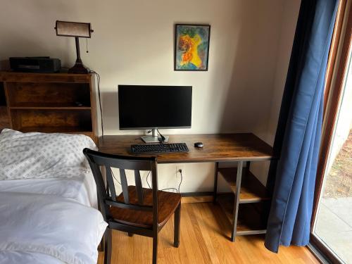 a desk with a computer on it next to a bed at earthship forest exile in Temple