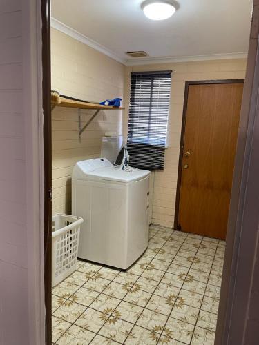 a bathroom with a sink and a tiled floor at Relax at Ruby in Mildura