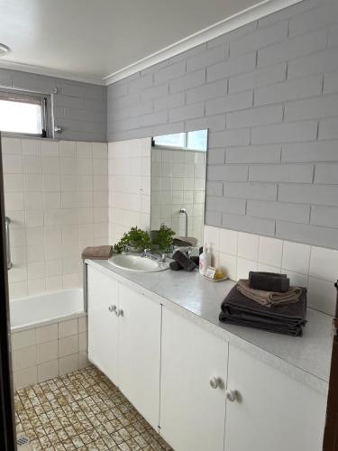 a bathroom with a sink and a tub and a mirror at Relax at Ruby in Mildura