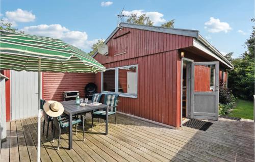 a deck with a table and chairs and a red building at Holiday Home Rønnemose Sydals Denm in Skovby