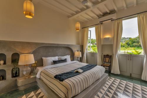 a bedroom with a large bed and a large window at La Rozalia, Exquisite 4 BHK Villas with Large Pool, Garden, Dedicated Caretaker, Terrace, 2 mins from the famous Dear Zindagi Road in Mapusa