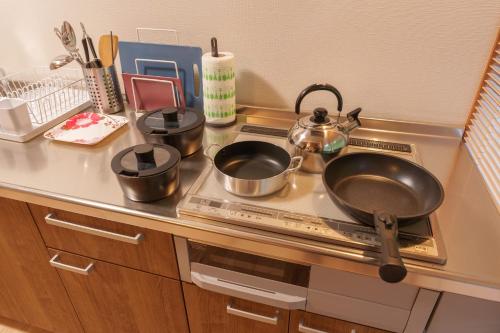 a kitchen counter with pots and pans on a stove at Takachiho Sanso Amaterasu Kagura in Takachiho