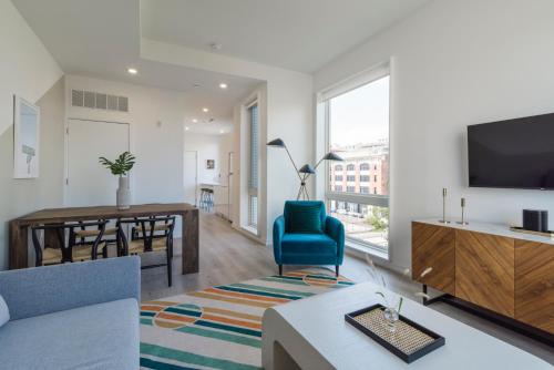 a living room with a blue chair and a tv at Abode XS House Stunning Architectural Flat in Philadelphia