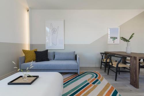 a living room with a blue couch and a table at Abode XS House Stunning Architectural Flat in Philadelphia