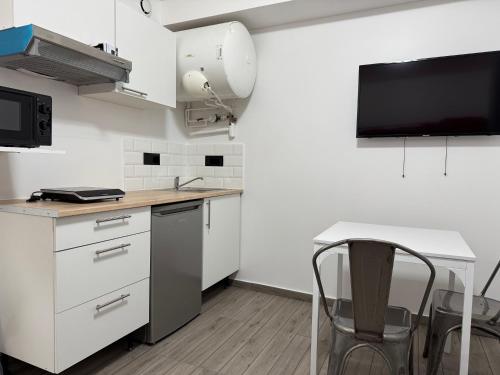 une cuisine avec des armoires blanches et un comptoir dans l'établissement Appartement F, RESIDENCE DU RENOUVEAU, Stade de France, idéal pour 2 pers, à Saint-Denis