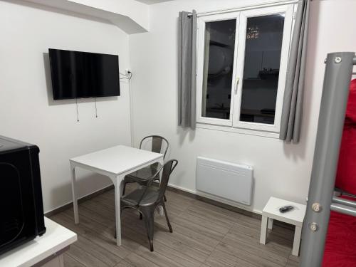 d'une petite table blanche et d'une chaise dans une chambre avec fenêtre. dans l'établissement Appartement F, RESIDENCE DU RENOUVEAU, Stade de France, idéal pour 2 pers, à Saint-Denis