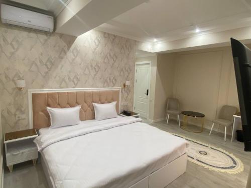a bedroom with a large bed with white sheets at Beksaroy in Samarkand