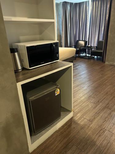 a living room with a microwave and a living room with a couch at S Hadyai Hotel in Hat Yai