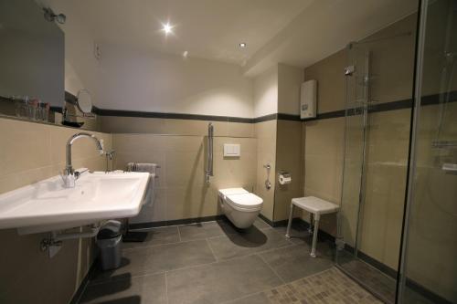 a bathroom with a sink and a toilet and a shower at Ferienwohnungen Haus Cramer in Winterberg
