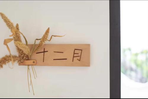 a wooden sign with two bees on it next to a window at Xiamen Mingshu Shanqiu Homestay in Xiamen