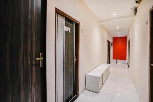 a hallway with a door and a white tile floor at FabExpress The United - Nr Mumbai International Airport in Mumbai