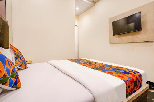 a bedroom with a bed with a colorful blanket at FabExpress The United - Nr Mumbai International Airport in Mumbai