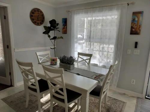 a dining room with a white table and chairs at Charming 4-Bedroom Family Haven in Saint Augustine