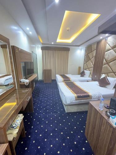 a hotel room with two beds and a television at فندق عين دره in Sawdāʼ