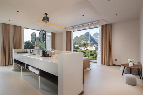 a bathroom with a sink and a large window at THAT MAY Hotel in Yangshuo
