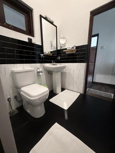 a bathroom with a white toilet and a sink at Ella moon rock in Ella
