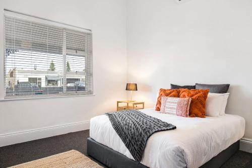 a bedroom with a large bed and a window at Salty Pines - 3BR House Glenelg South in Glenelg